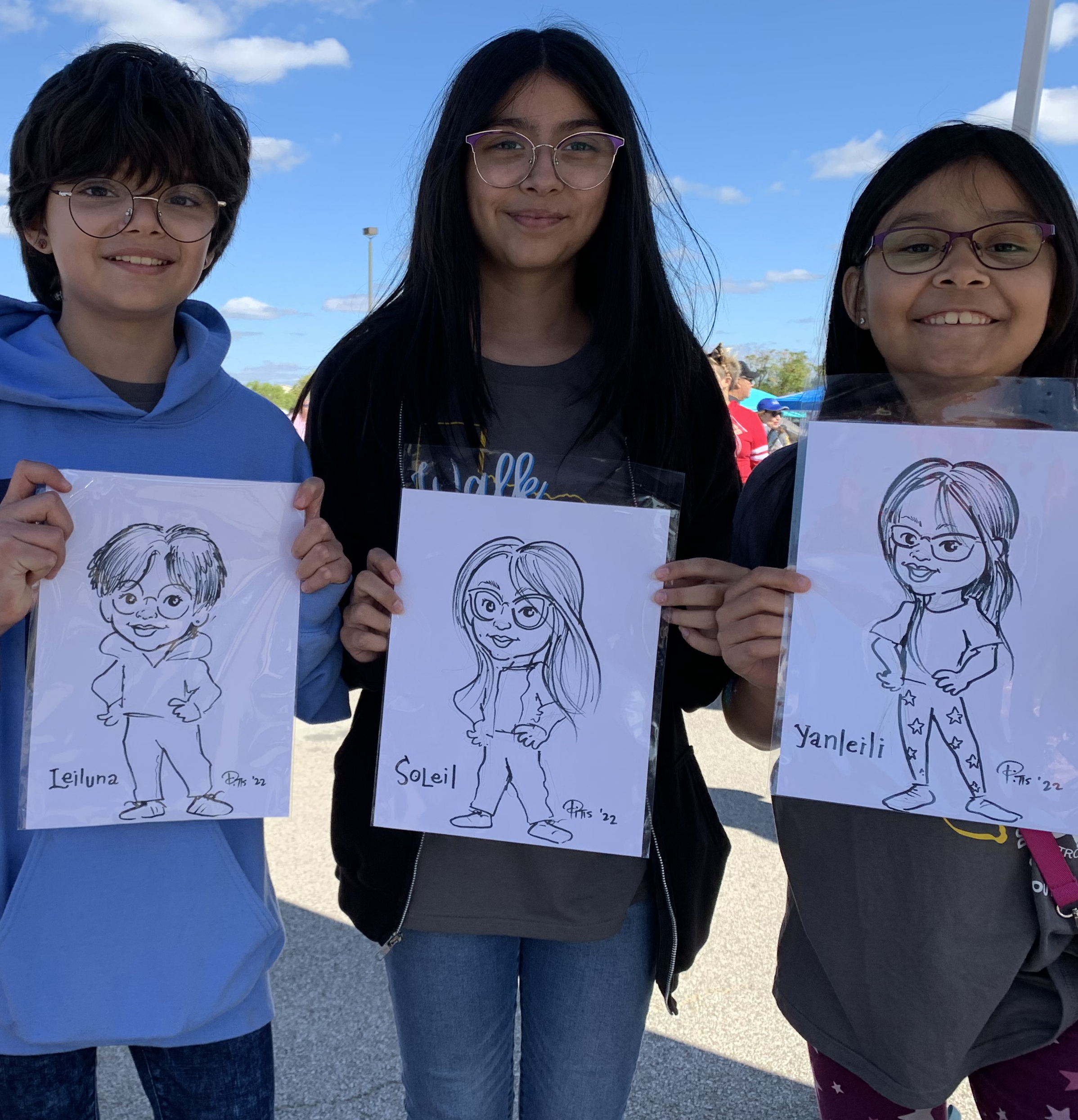 three young sisters smiling holding a cartoon caricature of themselves